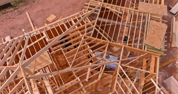 Building new house roof using wooden frame trusses for support beams as of construction process