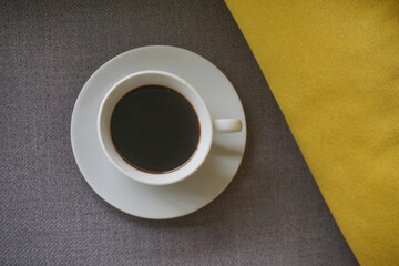 Coffee cup on the table with yellow pillow