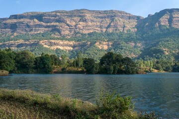 Fototapeta na wymiar Scenic view of Arthur Lake in Bhandardara, India is seen, with lush green hills and trees