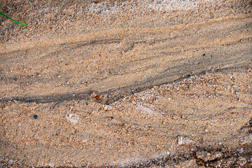 Geological detail of coarse sand gravel in the mountain woods with water flowing marks