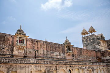 Woman inside Amber Fort in daytime with cloudy sky, near Jaipur, The Pink City, Rajasthan, India