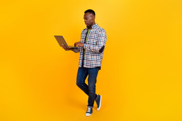 Fototapeta na wymiar Full length body photo of young serious businessman concentrated doing his job online on freelance isolated over yellow color background