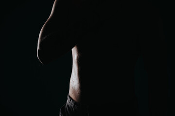 Fototapeta premium Confident Male Athlete Flexing Muscles in Studio Silhouette