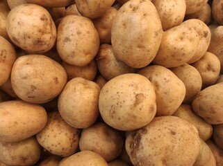  tempting display at the market, a mountain of freshly harvested potatoes sits in inviting mounds, promising culinary possibilities.