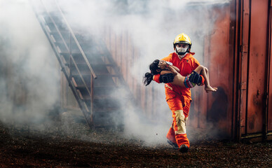 Fototapeta premium Firefighter to save girl in fire and smoke. Rescue Team or Firefighters save lives people from fire. Firefighter or Emergency team rescue saving life people from fire.