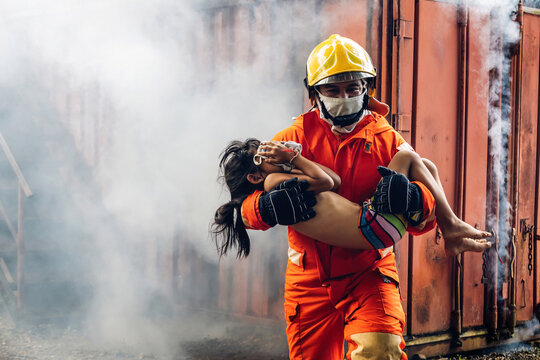 Firefighter to save girl in fire and smoke. Rescue Team or Firefighters save lives people from fire. Firefighter or Emergency team rescue saving life people from fire.