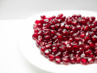 Close-up of a plate with a fresh pomegranates isolated on a white background