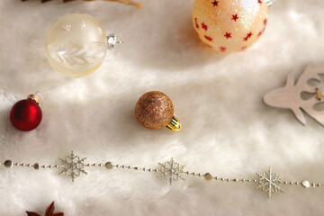 Various colorful Christmas oranments and white faux fur blanket. Selective focus.