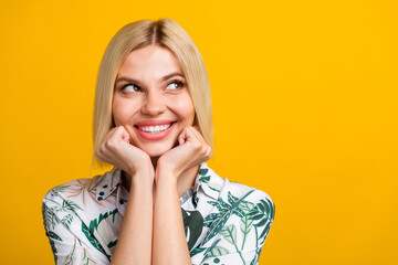 Photo portrait of pretty young girl admire look empty space dressed stylish leaves print outfit isolated on yellow color background