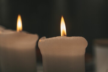 Closeup shot of lit candles against a blurry dark backdrop.