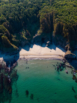 Aerial view of the rocky, wild coast of the Black Sea in Bulgaria, with cliffs, beaches, and green forests