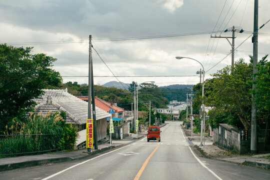  A red truck drives on a country road in Okinawa