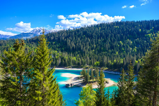 Small island in the middle of Cauma Lake (Caumasee) with crystal blue water in beautiful mountain landscape scenery at Flims, Graubuenden - Switzerland