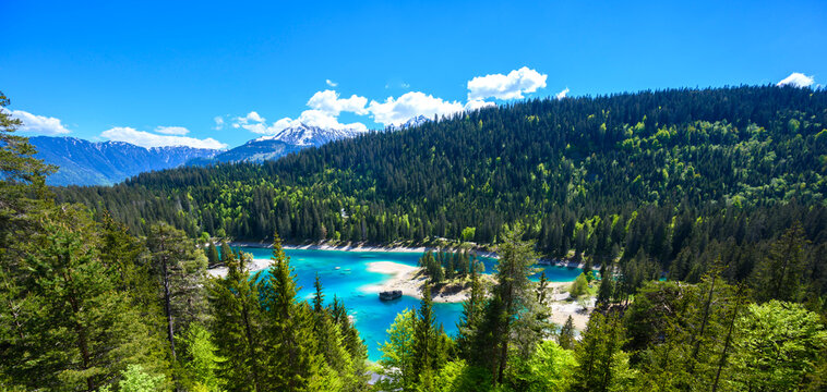 Small island in the middle of Cauma Lake (Caumasee) with crystal blue water in beautiful mountain landscape scenery at Flims, Graubuenden - Switzerland