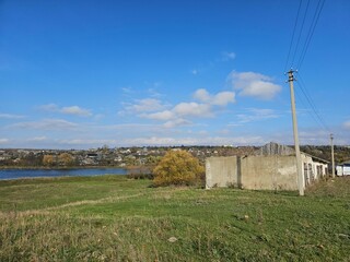 A grassy field with a fence and a body of water in the background