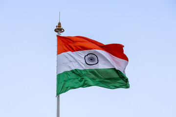 Indian flag fluttering in the wind in a blue sky with its orange, green and white colors