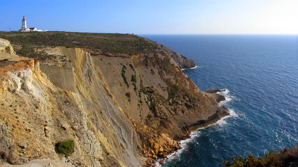 Espichel cape lighthouse sitting on top of a cliff overlooking the Atlantic Ocean. Sesimbra, Setubal, Portugal.