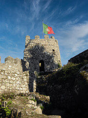 Medieval Castelo dos Mouros aka Castle of the Moors in Sintra, Portugal. Watchtower with Portuguese flag and defensive wall
