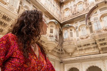Woman dressed in red inside Mehrangarh Fort in Jodhpur in Rajasthan, India. The blue city