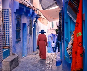 Papier Peint photo Lavable Maroc woman walking on the blue streets of Chefchaouen Morocco