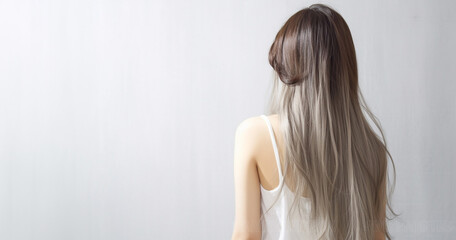 Obraz premium The rear view of a young woman with sleek, silver long hair, photographed in a studio with a white background and professional lighting. Generative AI.