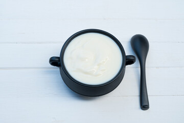 Fototapeta na wymiar Yogurt greek white clean In bowl with spoon on a wooden background from top view. 