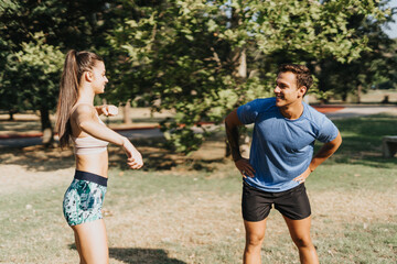 Caucasian couple enjoys a sunny day in the park, engaging in outdoor workouts. With emphasis on fitness and healthy living, they demonstrate persistence and dedication.