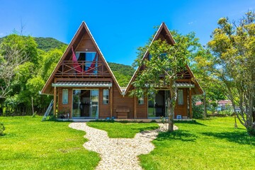 Picturesque rustic cabin-style homes located side-by-side in a lush, grassy field