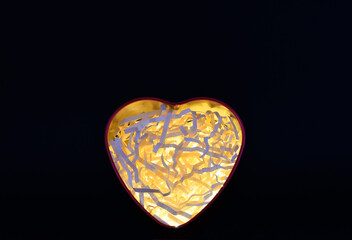 Corazón iluminado sobre fondo negro, concepto del día de San Valentín. 
