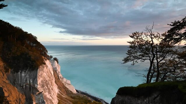 Time lapse: sunrise landscape of the magnificent chalk cliffs of Møns Klint, rising high above the Baltic Sea. Clouds moving over the turquoise waters of the Baltic Sea.  Denmark's highest cliff. 