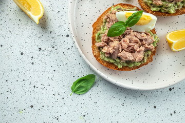 Tuna sandwich with avocado and boiled egg on plate. Food recipe background. Close up