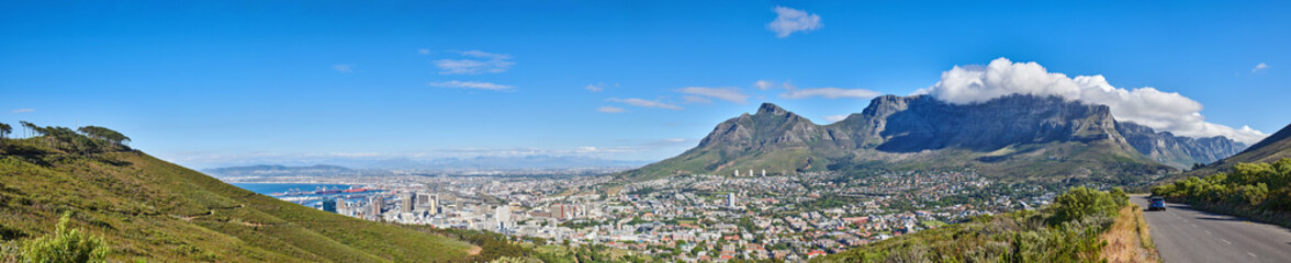 Fototapeta na wymiar Mountain landscape and panorama view of coastal city, residential buildings or infrastructure in famous travel or tourism destination. Copy space and scenic blue sky of Table Mountain in South Africa