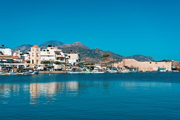Naklejka na ściany i meble Picturesque harbor, with several boats moored in the water in Ierapetra, Crete, Greece