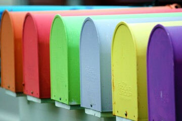 Array of multi-colored post boxes stacked on a ledge in a neat formation