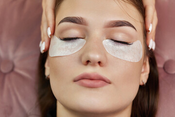cosmetologist preparing glue cotton strip under eye. Eyelash extension procedure