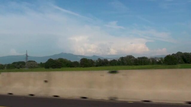 Ripresa di un campo in Italia dal finestrino di una macchina che viaggia in autostrada ad alta velocit&agrave;