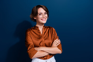 Photo portrait of pretty young girl folded arms toothy smile wear trendy brown blouse isolated on dark blue color background - obrazy, fototapety, plakaty