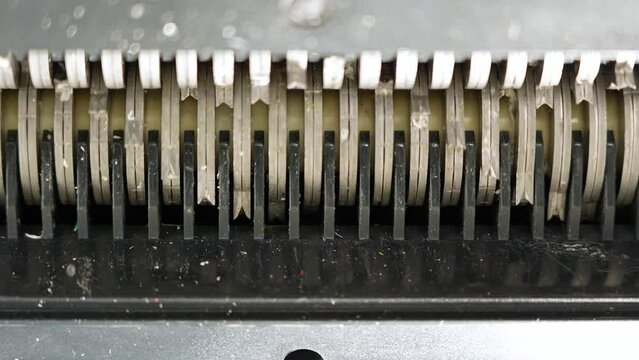 Clean teeth of the shredder rotation, no paper. Document shredder from below. Used for cut and destroy document with sensitive information, top secret, classified, personal identity thief protection.