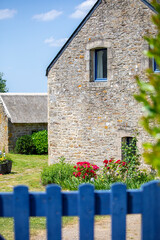 Maison bretonne et ses muret de pierre au pied d'un charmant petit jardin.