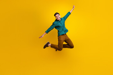 Full length photo of satisfied man flying air rejoicing celebrating black friday isolated on yellow color background