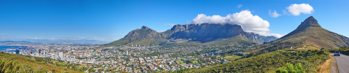 Fototapeta na wymiar Wide angle of Cape Town and mountain landscape on a sunny day. Panoramic view of a city against a blue horizon. A popular travel destination for tourists and hikers, in Lions Head, South Africa