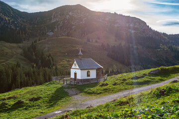 Fototapeta na wymiar Wandern am Hinteren Sonnenwendjoch in Tirol, Österreich nahe der bayerischen Grenze und der Ackernalm - Kapelle im herbstlichen Gegenlicht