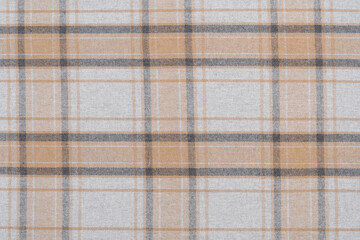 Texture of warm tartan fabric in beige and gray check. Traditional Scottish clothing. Background for your mockup