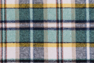 warm fabric texture in traditional Scottish check in black, turquoise and yellow colors. material for sewing clothes concept. background for your mockup