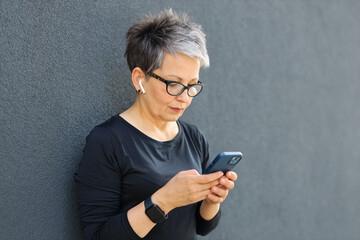 A woman of various ages using a smartphone in an urban setting, blending technology with a positive...