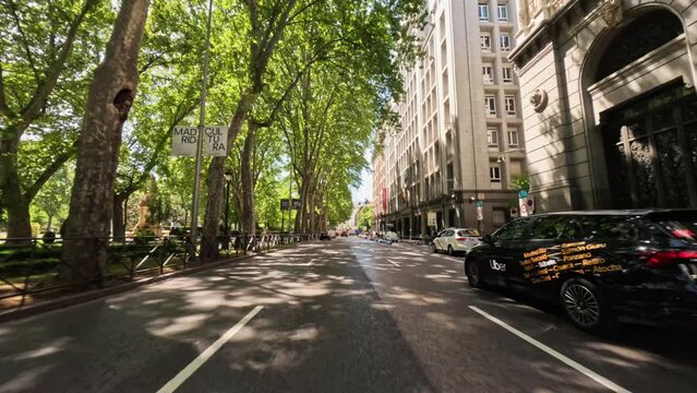 Point of view car driving on Gran Via street of Madrid city center on a beautiful sunny day