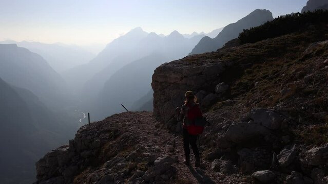 Solo Hiker Descending from High Mountains with a beautiful view of Trenta Valley and River Soca - Slovenia