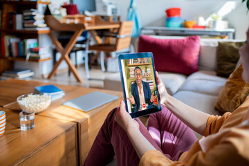 Young woman talking to teacher on a video call from home
