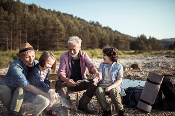 Grandparents and grandchildren camping in nature