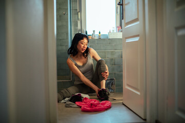 Young woman taking her shoes off after a workout